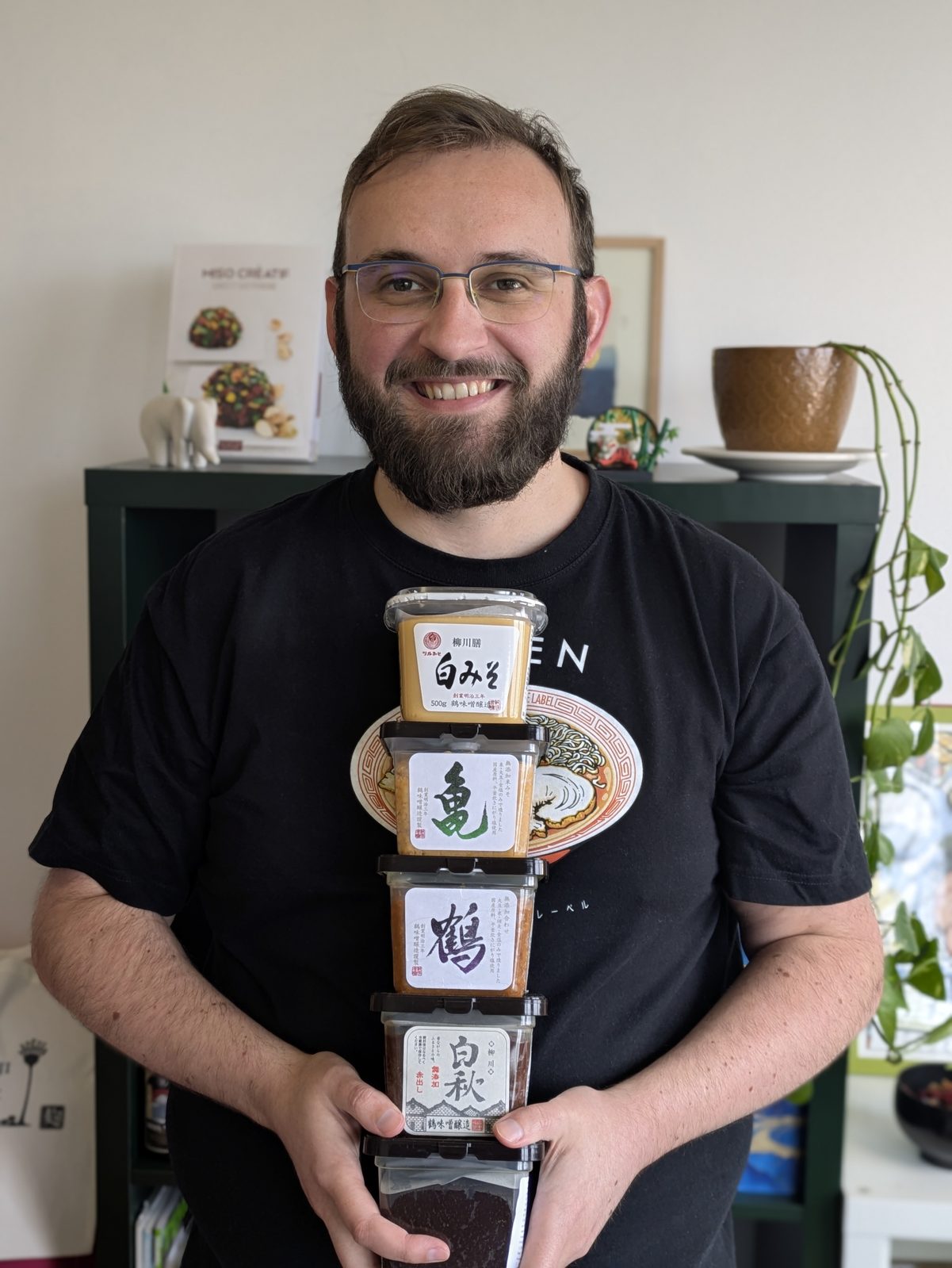 Portrait d'Alexandre tenant une pile de pots de miso Tsurumiso