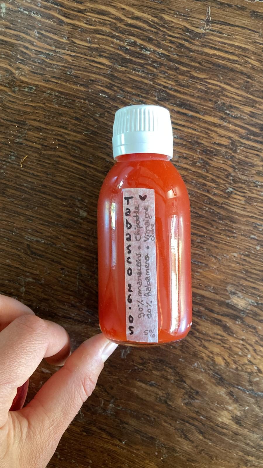 Bouteille de tabasco maison tenue en main