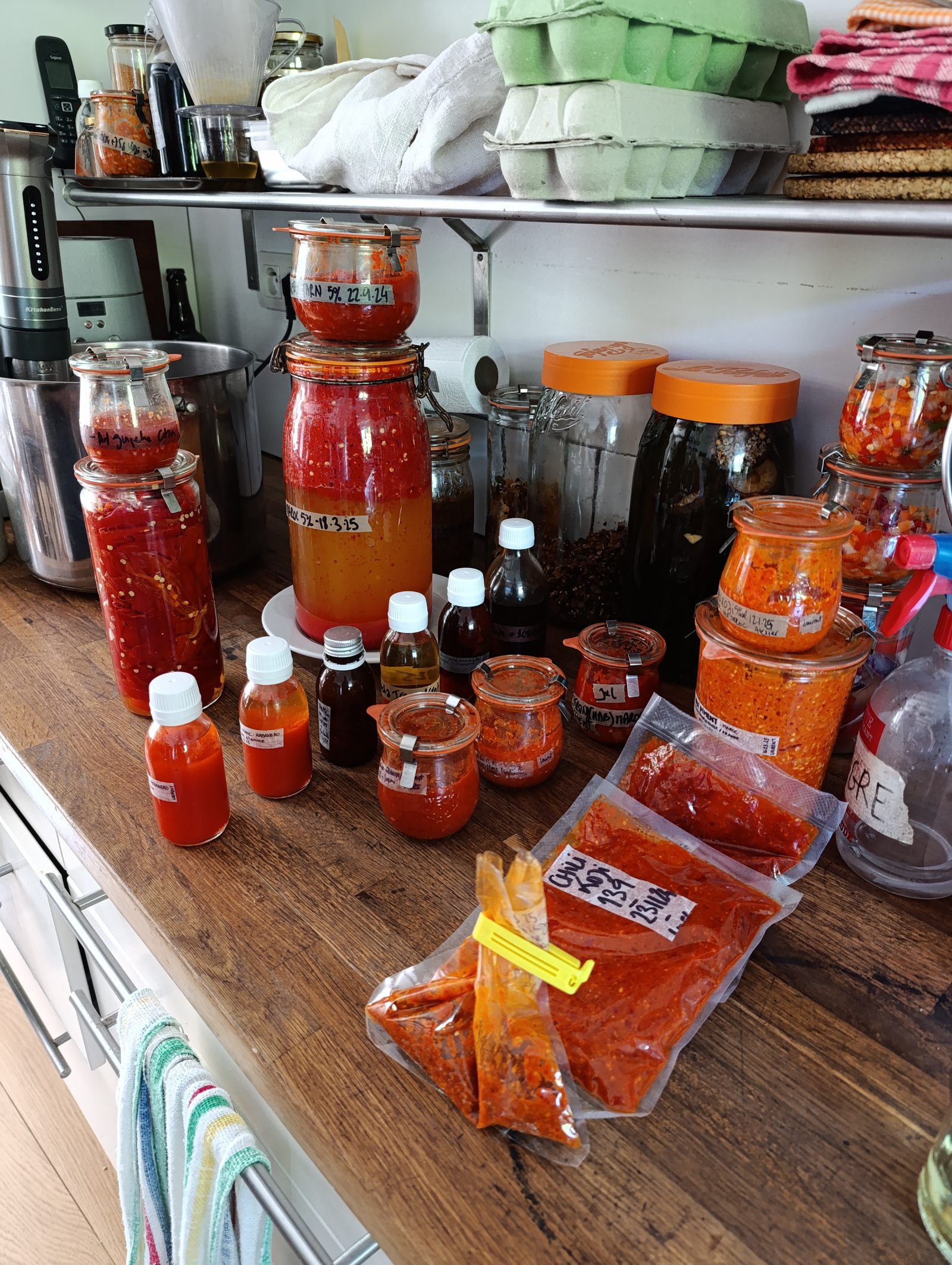 Grande table couverte de bocaux et bouteilles de ferments